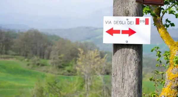 Segnavia della Via degli Dei, con frecce rosse che indicano direzioni opposte. Perfetto per pianificare le tappe 5 giorni.
