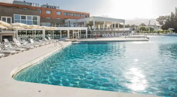 Piscina con lettini e ombrelloni in un resort a Venturina Terme. Un'oasi di relax dove godersi il sole e l'acqua cristallina, un'esperienza quasi venturina terme kostenlos.