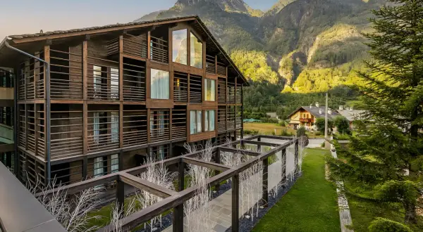 Edificio in legno con balconi e vista su una montagna vicino Milano in estate.
