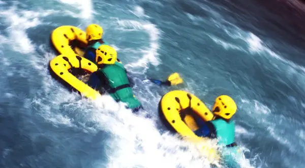 Persone su gommoni gialli affrontano rapide turbolente, un'avventura di sport in mare.