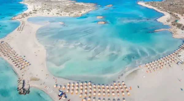 Spiaggia di Elafonissi, dove si trova Creta, con acque turchesi e sabbia rosa.
