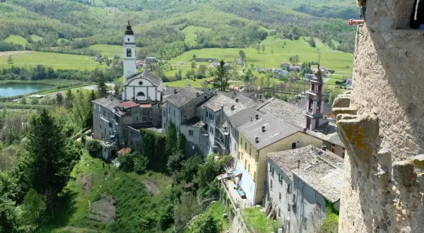 Un borgo incantevole con un campanile bianco, tetti in pietra e colline verdi. Un luogo dove compiano cosa vedere, tra storia e natura.