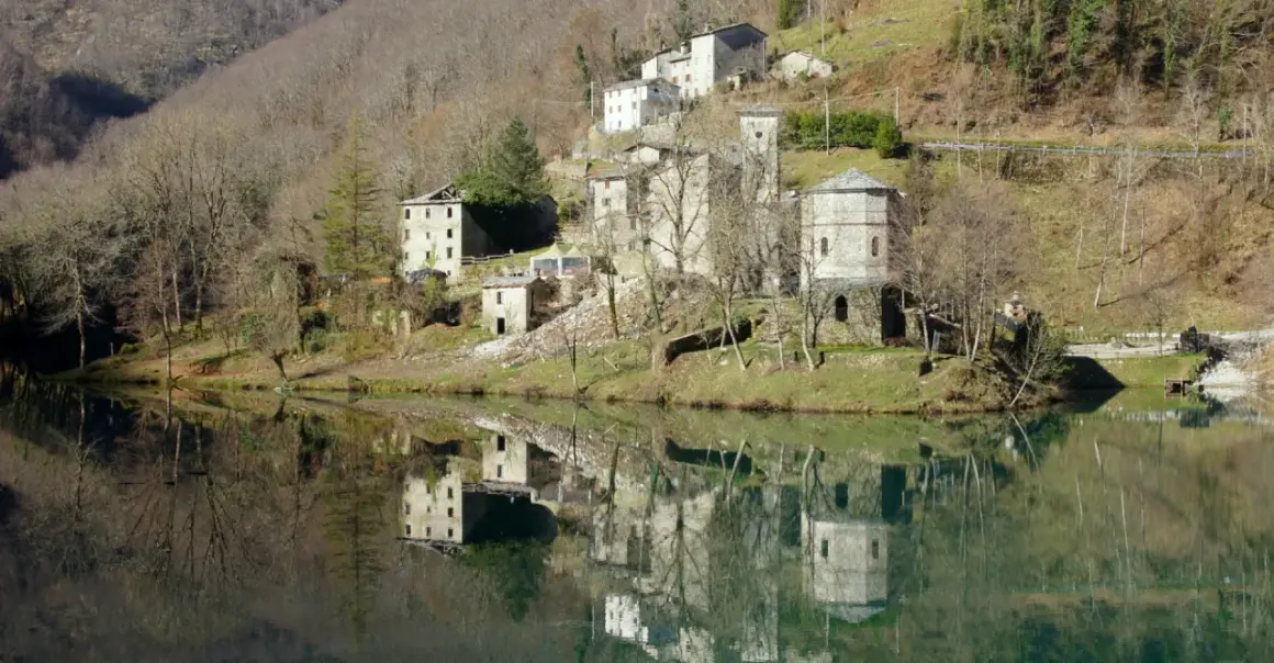 Borghi antichi e riflessi sull'acqua: ecco cosa vedere in Garfagnana. Un paesaggio incantevole con case in pietra e torri medievali.