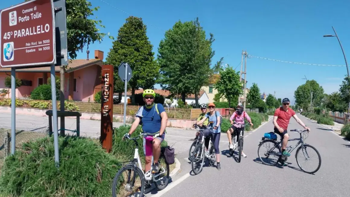 Ciclisti lungo il percorso fiume Po, vicino al cartello del 45° parallelo a Porto Tolle.
