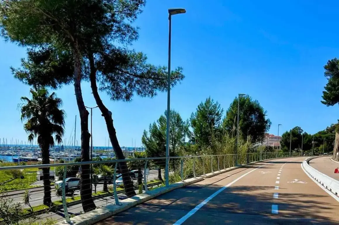 La ciclabile di Imperia, con palme e pini, si snoda verso il porto turistico. Un percorso ideale per godersi il mare e la natura.