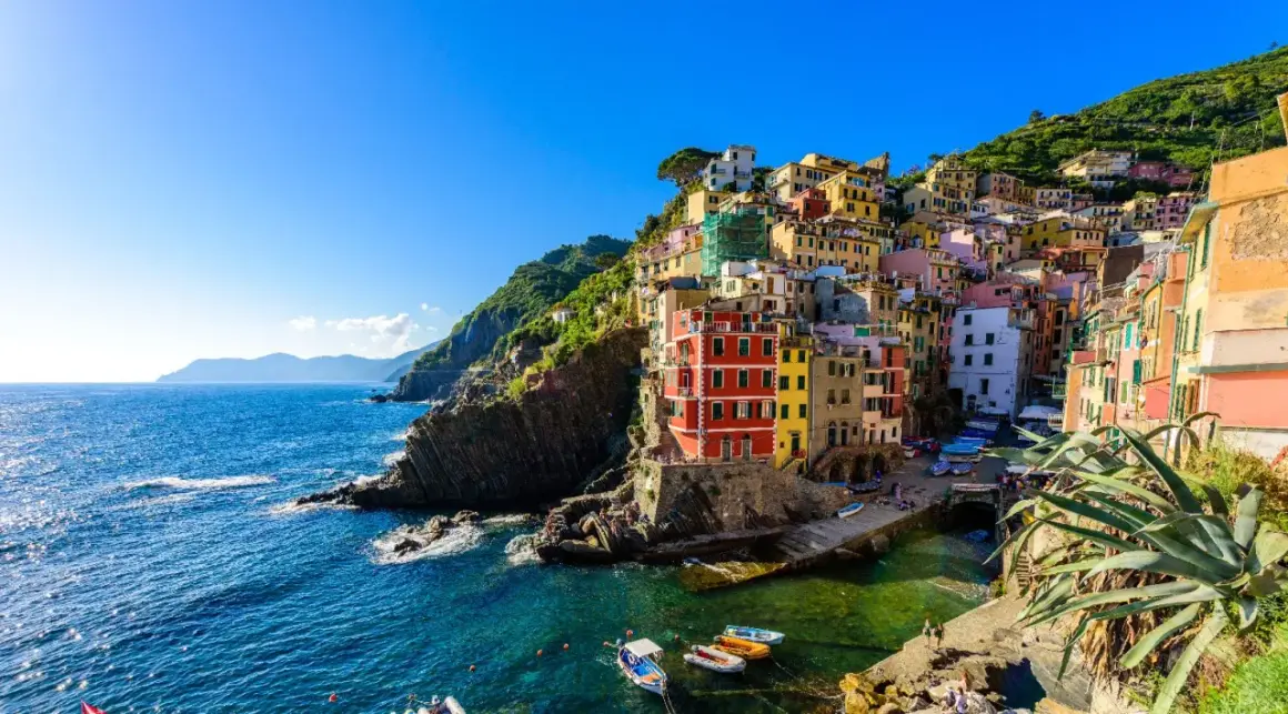 Riomaggiore, uno dei i 10 borghi più belli della Liguria, con le sue case colorate a picco sul mare blu.