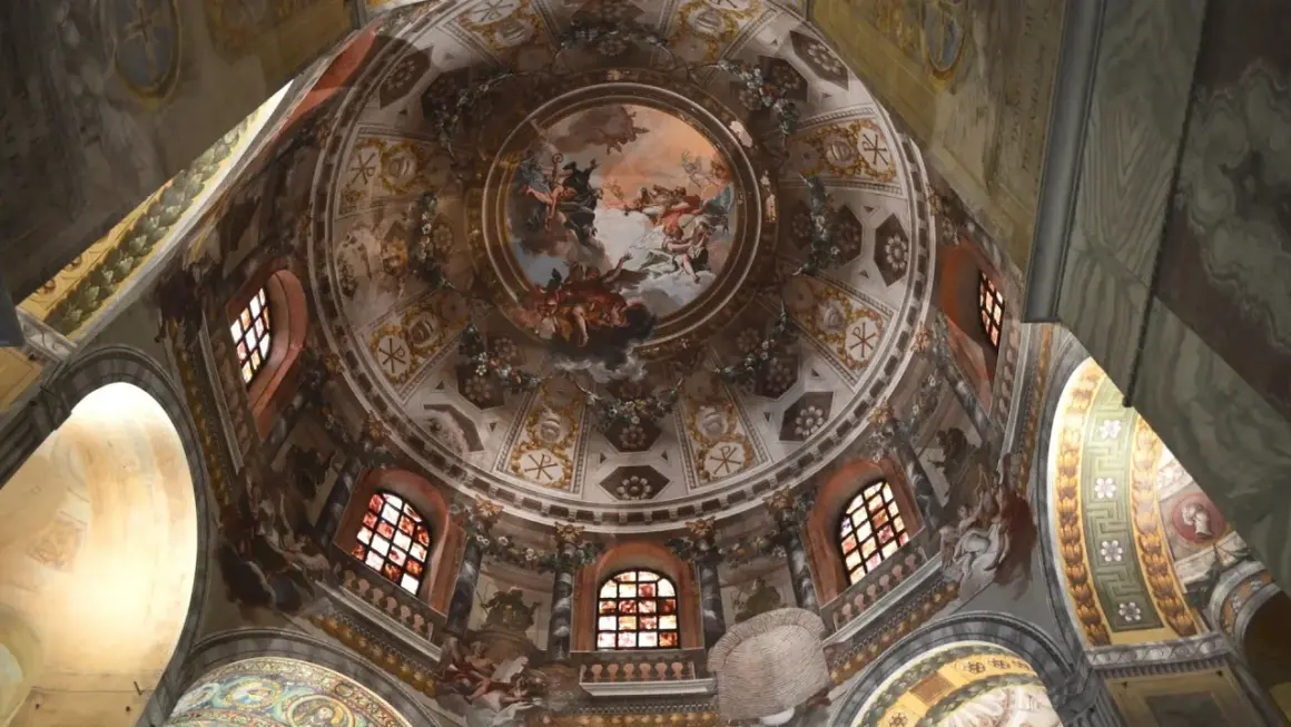 Cupola affrescata con scene celesti e simboli cristiani, un capolavoro da non perdere per chi visita Ravenna cosa vedere in un giorno.