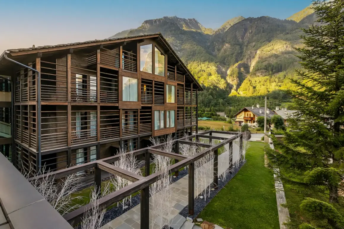 Edificio in legno con balconi e vista su una montagna vicino Milano in estate.
