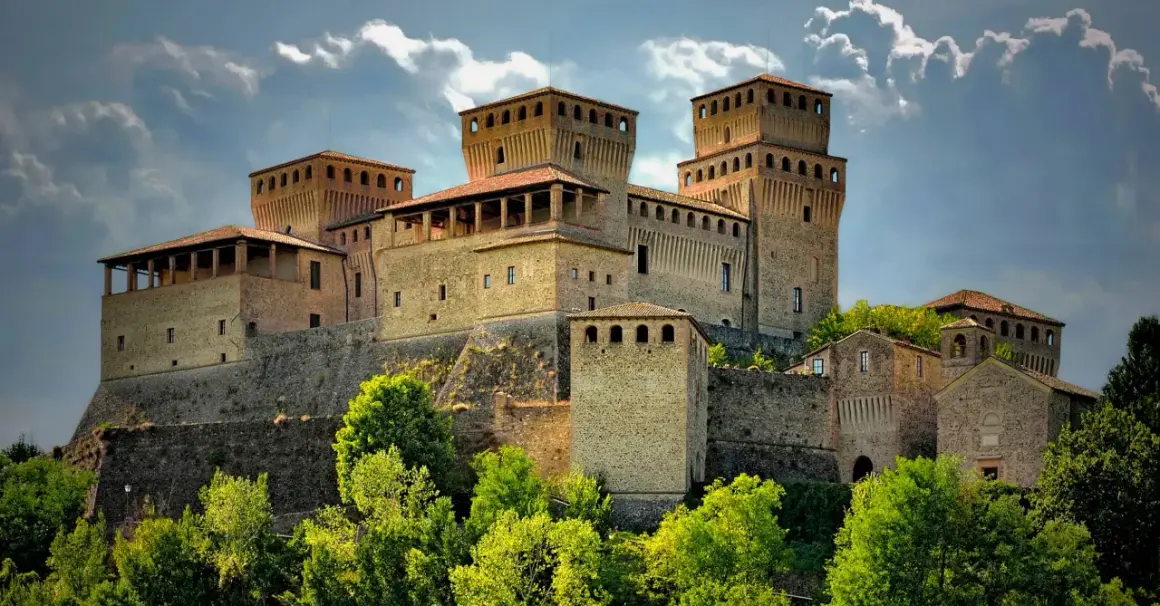 Roccastraordinaria di Torrechiara, un gioiello incastonato tra le colline di Parma, Emilia Romagna, con torri imponenti e un cielo drammatico.