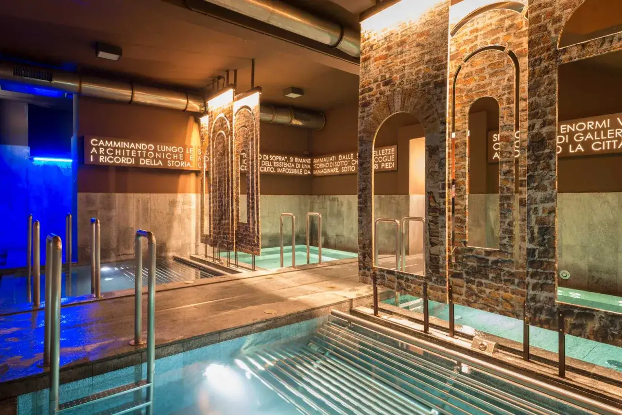 Piscine interne con luci blu e scritte evocative, un'esperienza unica nelle terme di Torino.