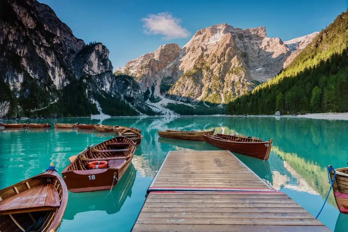 Barche di legno sul lago turchese, montagne maestose sullo sfondo. Un vero angolo di paradiso, un passo dal cielo a San Candido.