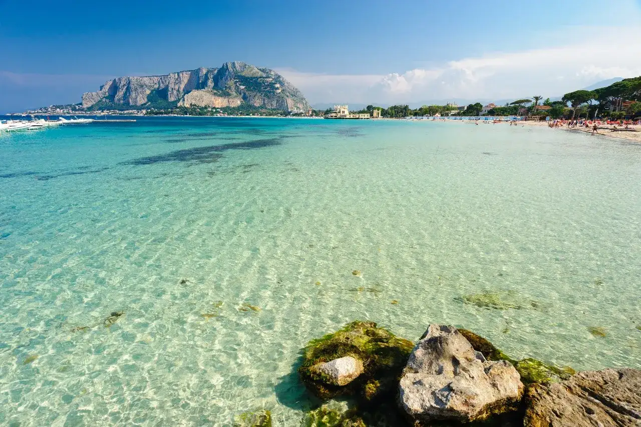 Splendido mare cristallino vicino Palermo, con la costa e il Monte Pellegrino sullo sfondo.