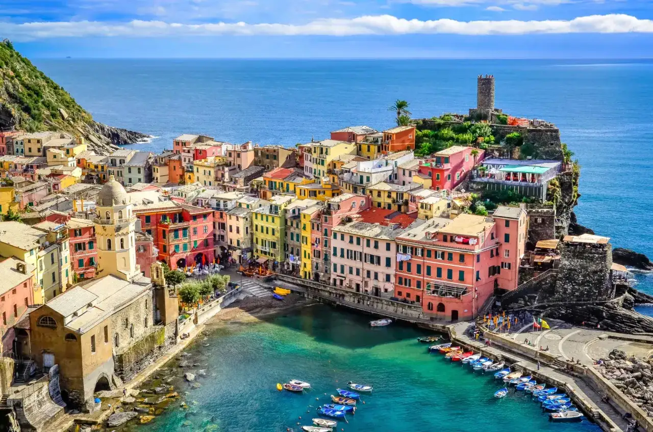Vernazza, uno dei i 10 borghi più belli della Liguria, con case colorate a picco sul mare e un porticciolo pieno di barche.