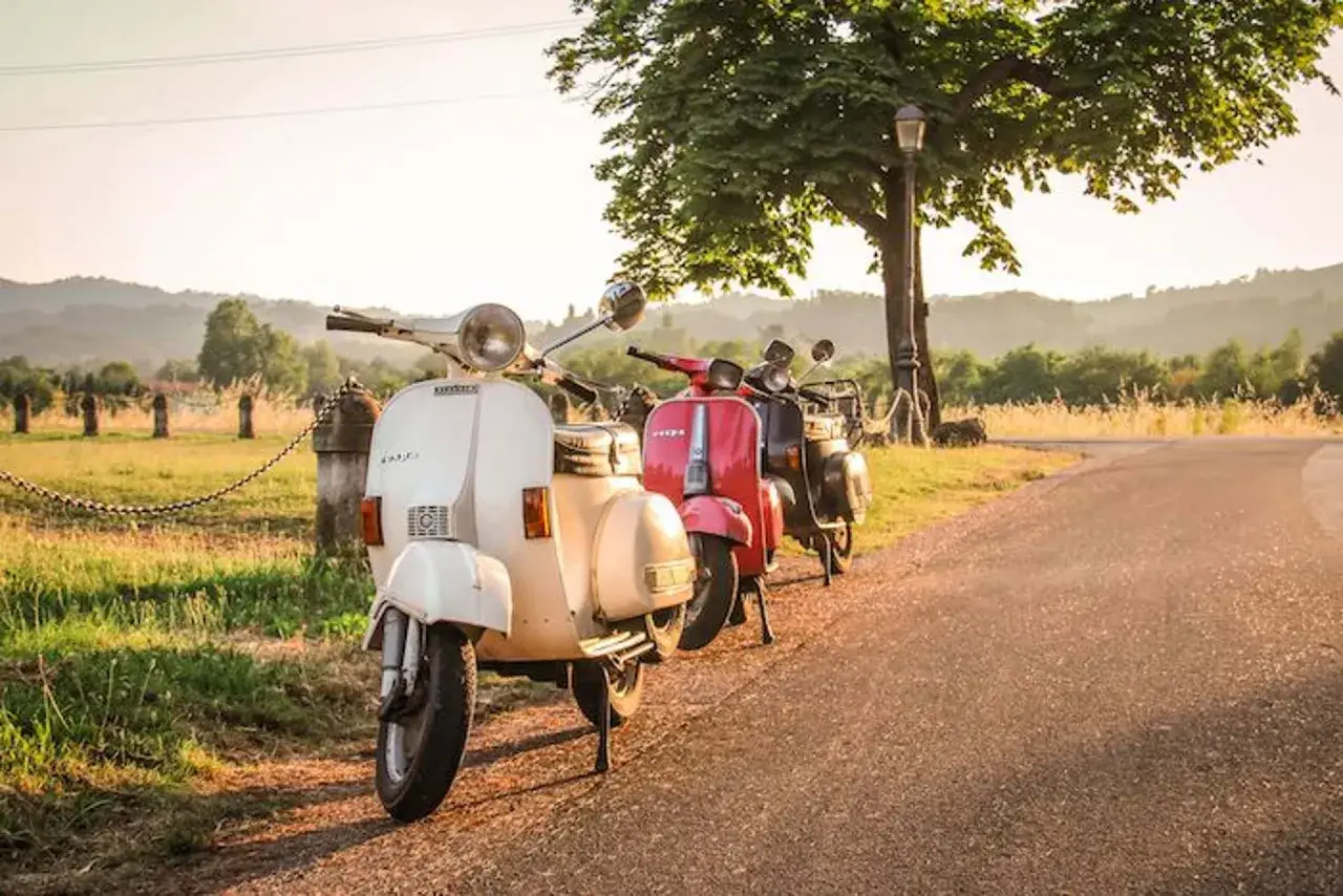 Scooter d'epoca parcheggiate lungo una strada panoramica sui colli bolognesi, pronte per un'avventura.