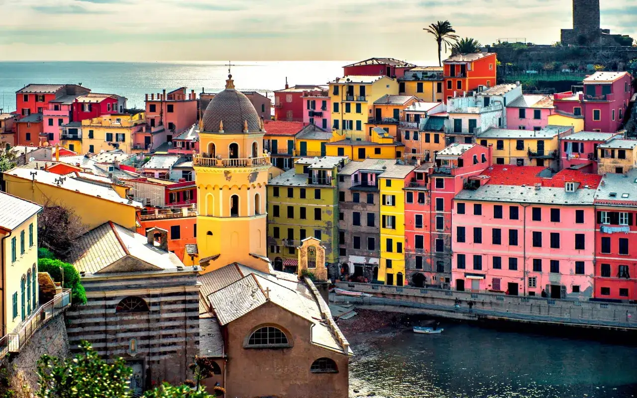Coloratissimi borghi sul mare, con case a picco sull'acqua e un campanile giallo che domina il paesaggio.