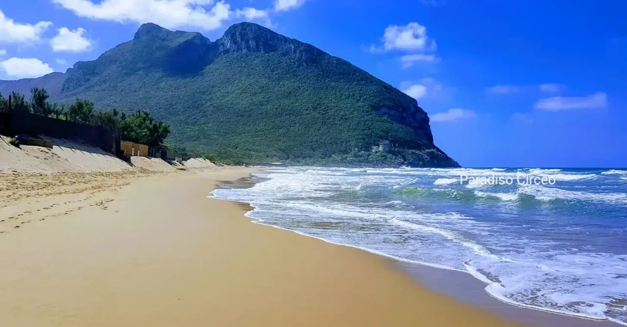 Spiaggia dorata e mare mosso sotto il Monte Circeo. Un angolo di paradiso, il Circeo mare incanta con la sua bellezza selvaggia.