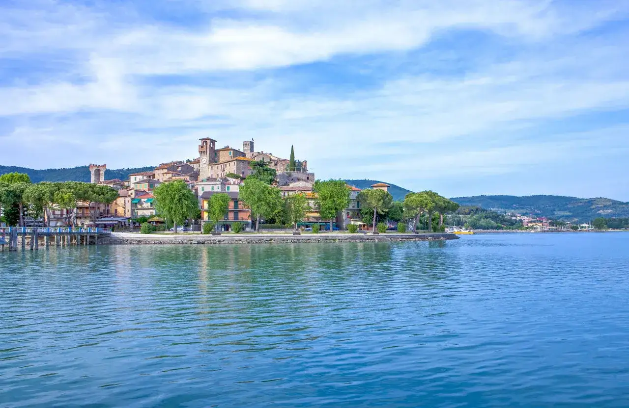 Borgo medievale sul lago Trasimeno, con torri e case colorate. Un luogo incantevole da scoprire, ecco cosa vedere a Passignano sul Trasimeno.