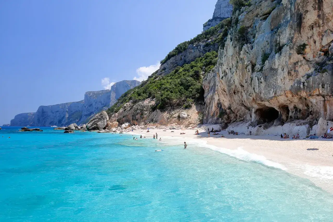 Spiaggia incantevole sulla costa di Baunei, con acque cristalline e imponenti scogliere calcaree.