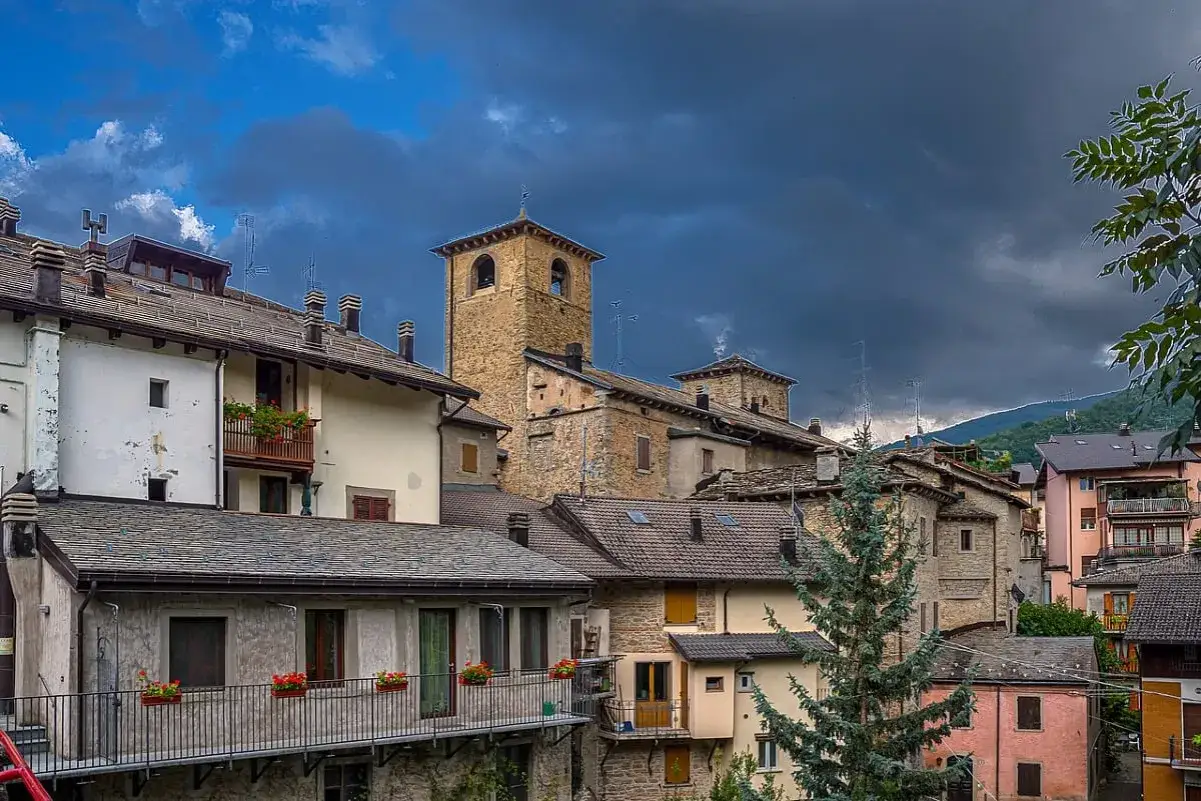 Antico campanile domina un gruppo di case in pietra e intonaco, tipici dei borghi sconosciuti dell'Emilia Romagna.