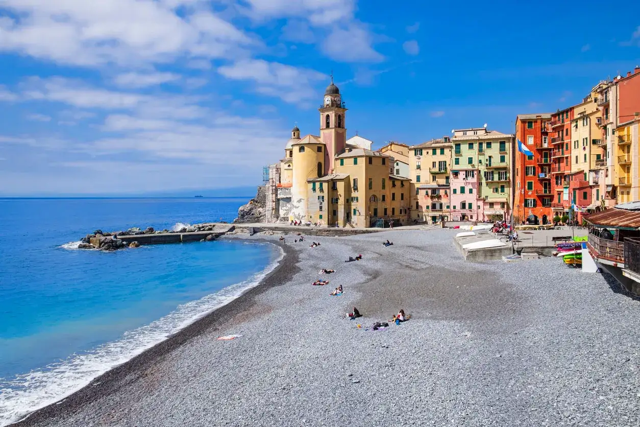 Camogli, un gioiello dove andare in Liguria al mare. Spiaggia di ciottoli, case colorate e mare azzurro.