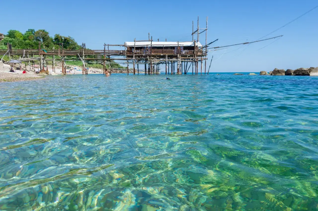 Acque cristalline e un trabocco in Abruzzo, perfetti per le tue vacanze al mare.