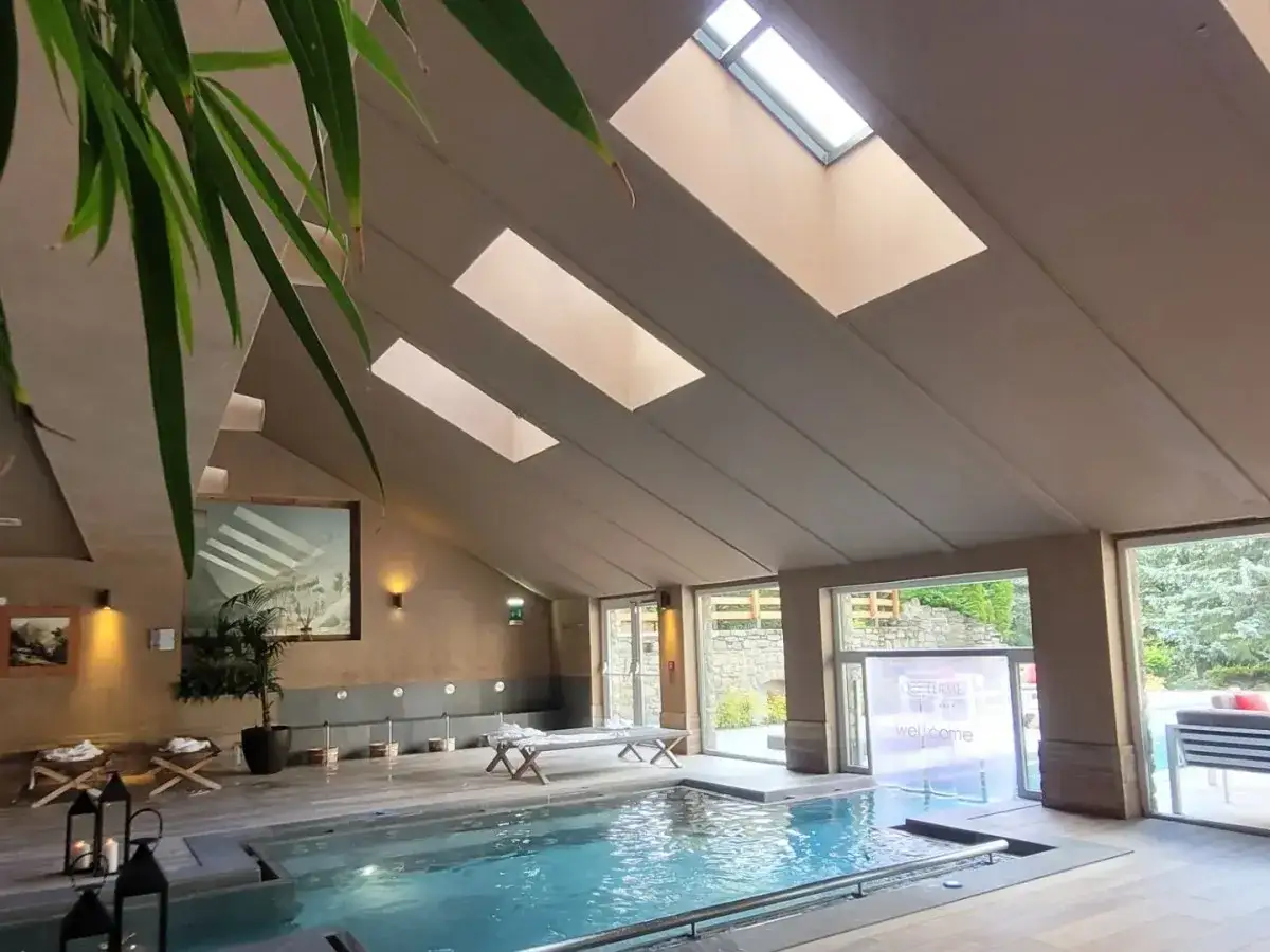 Interno di una spa con piscina, lettini e lucernari. Un'oasi di relax alle terme di San Pellegrino.