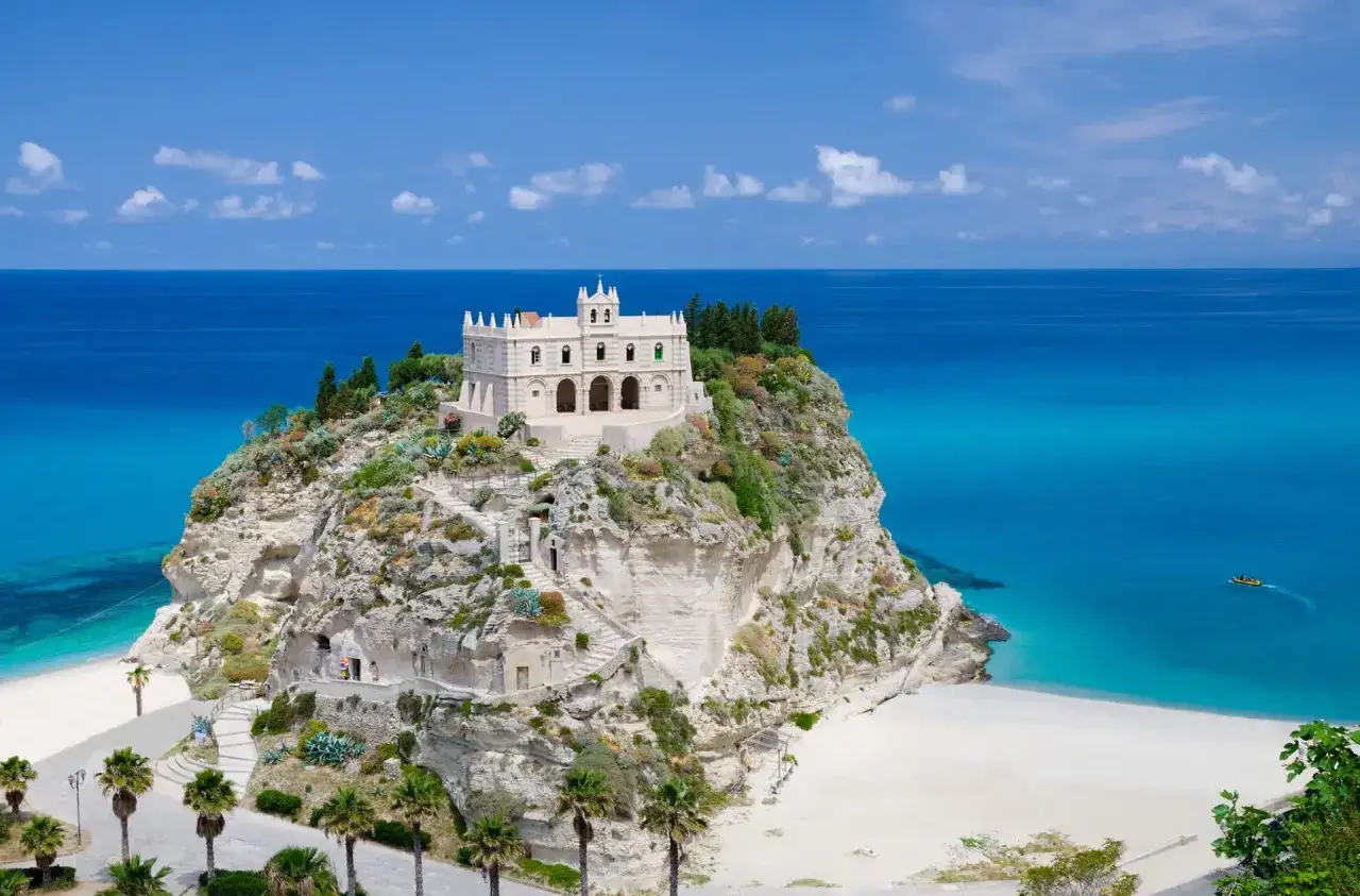 Santuario su uno sperone roccioso a picco sul mare cristallino, con spiagge bianche e palme. Un sogno di spiagge Tropea.