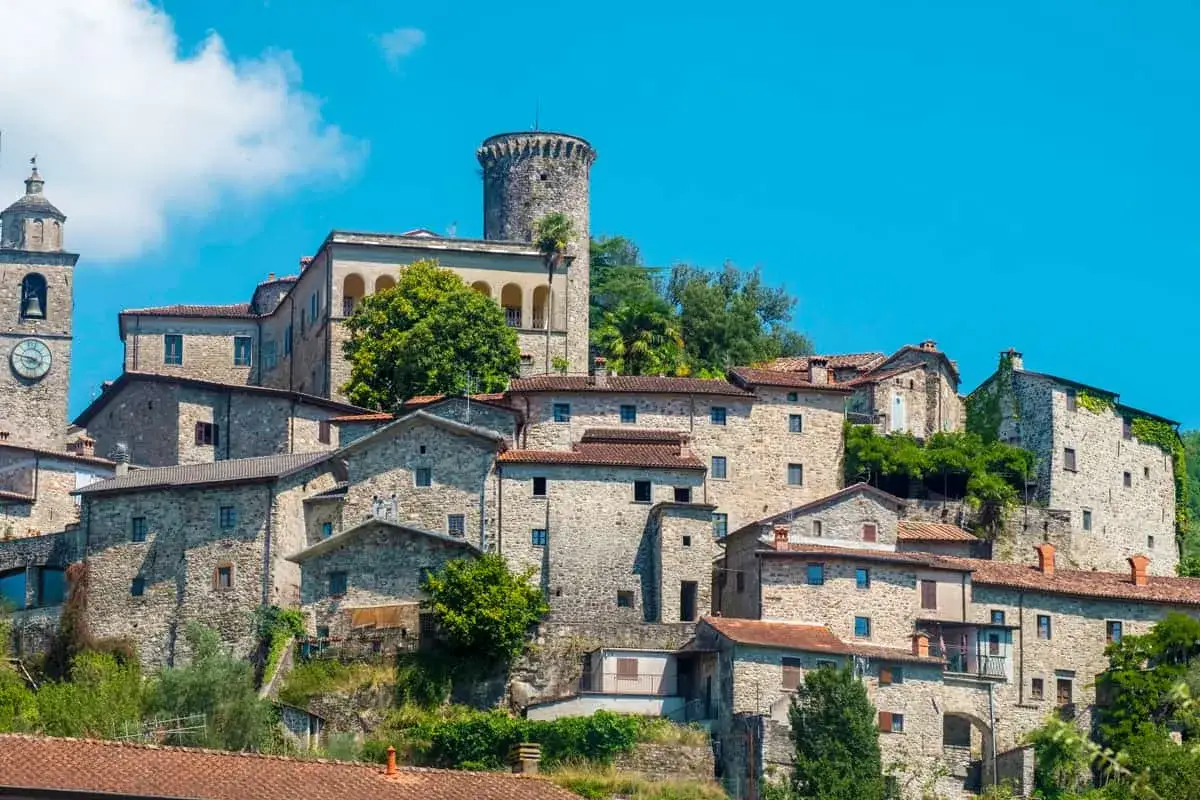 Antico borgo sull'Appennino Tosco Emiliano, con case in pietra e una torre medievale.