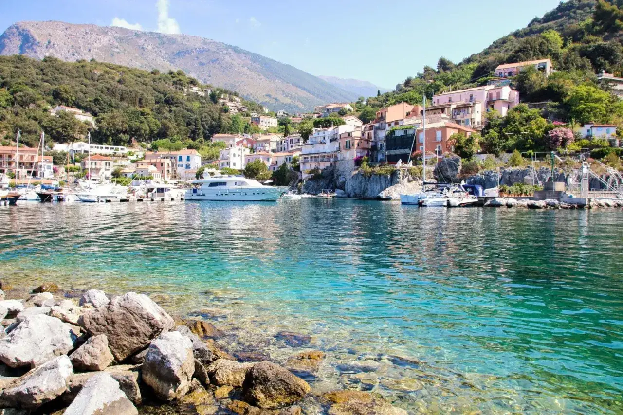Il golfo con Maratea, un incantevole borgo affacciato su acque cristalline, con yacht e case colorate aggrappate alla collina.