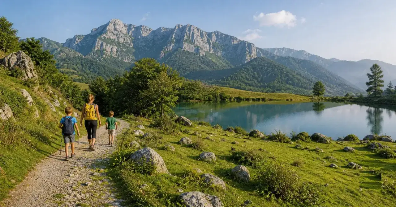 Famiglia in escursione sul sentiero con lago alpino e montagne sullo sfondo: ecco cosa vedere in Garfagnana per un'avventura indimenticabile.