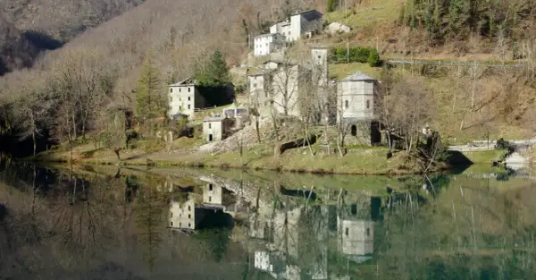 Borghi antichi e riflessi sull'acqua: ecco cosa vedere in Garfagnana. Un paesaggio incantevole con case in pietra e torri medievali.