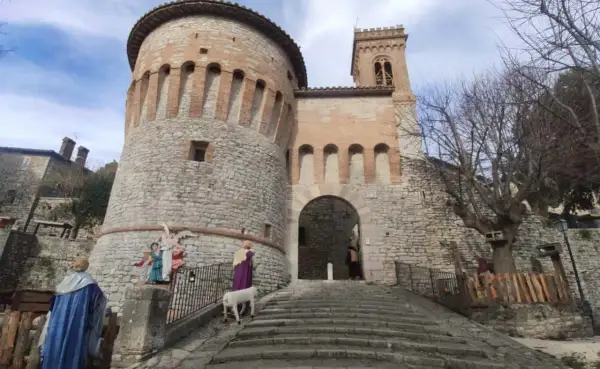Presepe vivente a Corciano: cosa vedere. La rocca medievale fa da sfondo a figure sacre e un agnello.