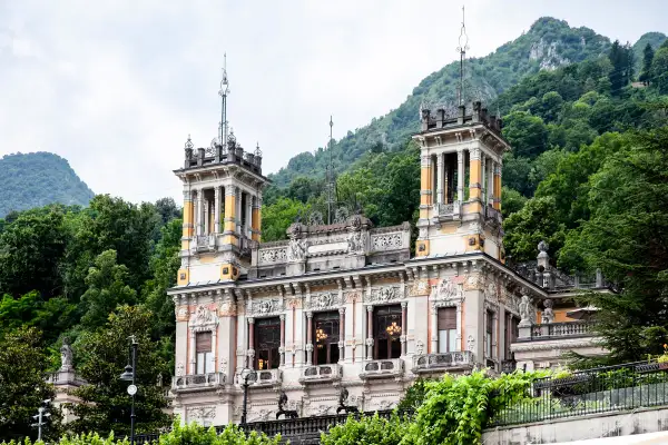 Edificio storico con torri e decorazioni elaborate, immerso nel verde delle montagne. Un luogo incantevole per una **spa San Pellegrino**.
