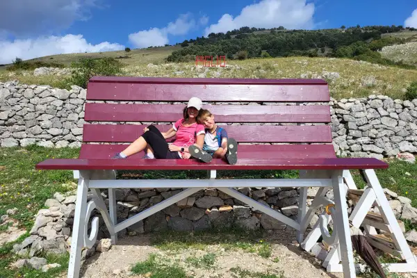 Una donna e un bambino si godono una pausa su una panchina in una montagna vicino Roma.