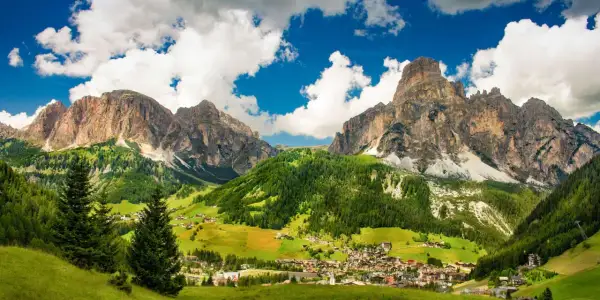 Un villaggio alpino incastonato tra imponenti vette rocciose e verdi pascoli. Una splendida località di montagna.