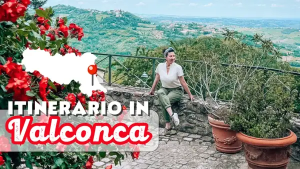 Un itinerario in Valconca, Rimini, tra colline verdi e rose rosse. Una donna sorride godendosi il panorama.