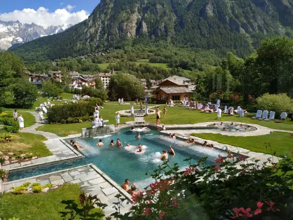 Un resort con piscine termali e persone rilassate, circondato da montagne verdi. Un'oasi di pace, quasi come le terme di Torino ma in montagna.