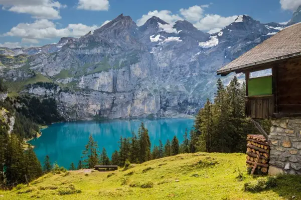Incantevole montagna in Italia con lago turchese e baita in legno.
