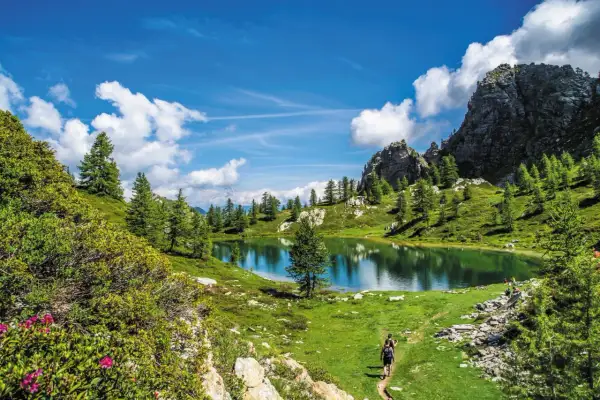 Sentiero panoramico nella Valle Maira, cosa vedere: un lago alpino specchiato, rocce imponenti e sentieri verdi.