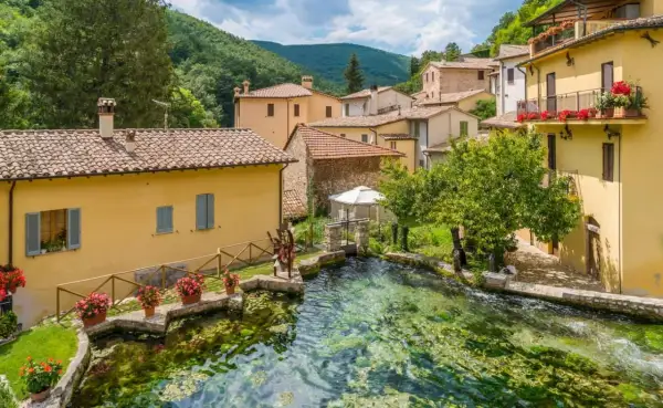 Borgo pittoresco con case gialle e un ruscello cristallino. Un'ottima meta per scoprire cosa vedere vicino Assisi.