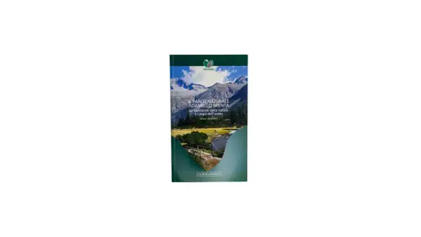 Copertina del libro "Il Parco Naturale Adamello Brenta", con montagne innevate, un fiume e un ponte.