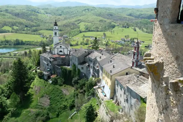 Un borgo incantevole con un campanile bianco, tetti in pietra e colline verdi. Un luogo dove compiano cosa vedere, tra storia e natura.